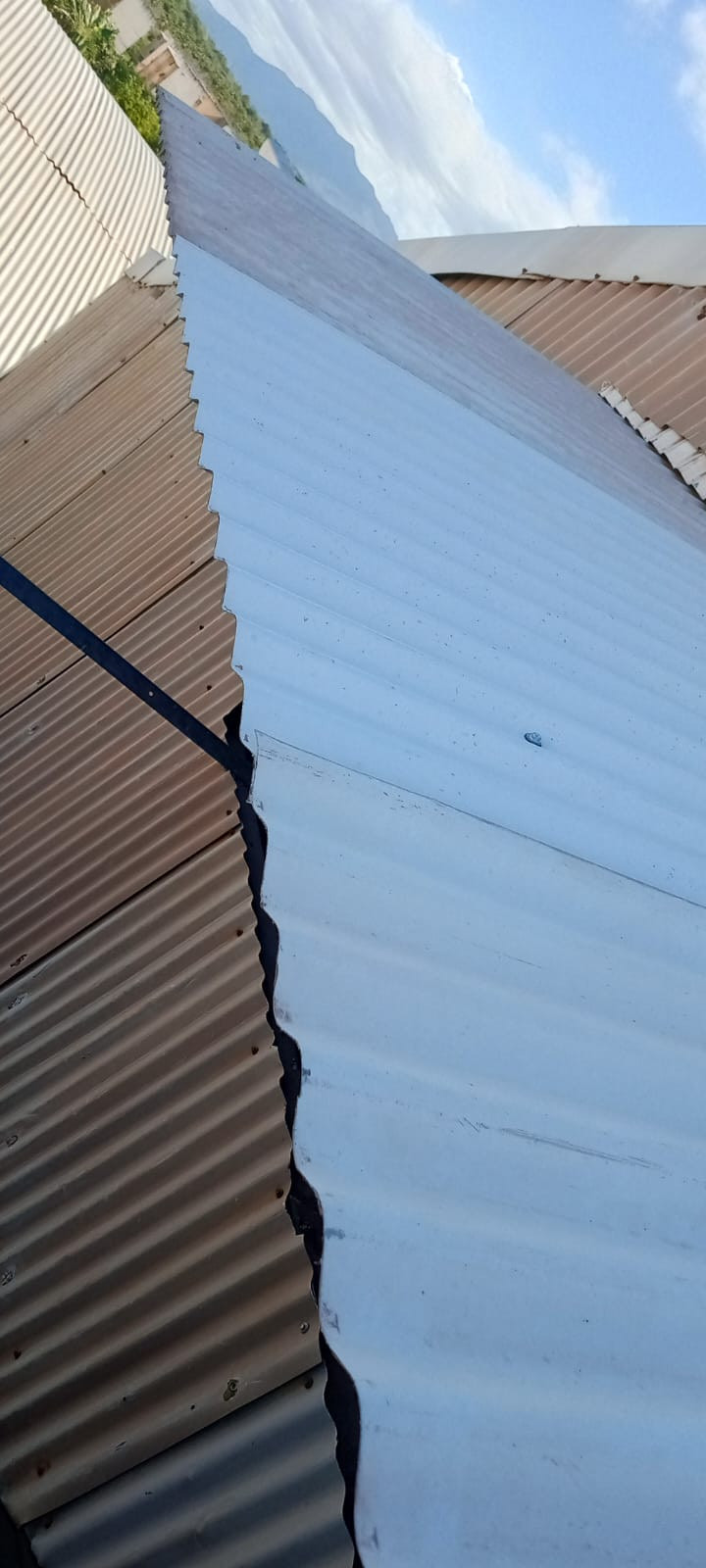 Cobertura metálica industrial em composição diagonal contra céu azul, obra de cobertura Engemec