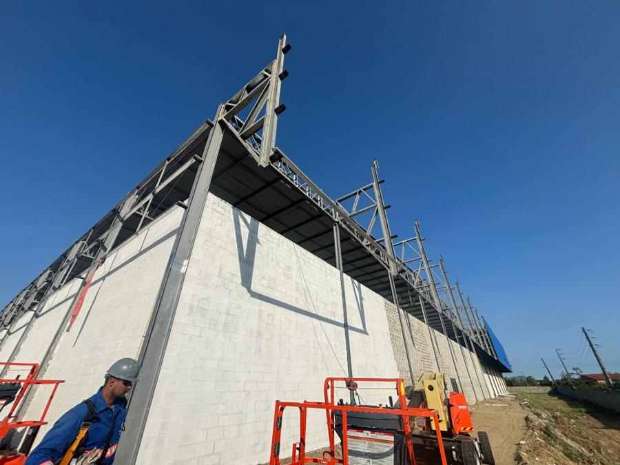 Estrutura metálica industrial em contraluz contra céu azul, montagem Engemec