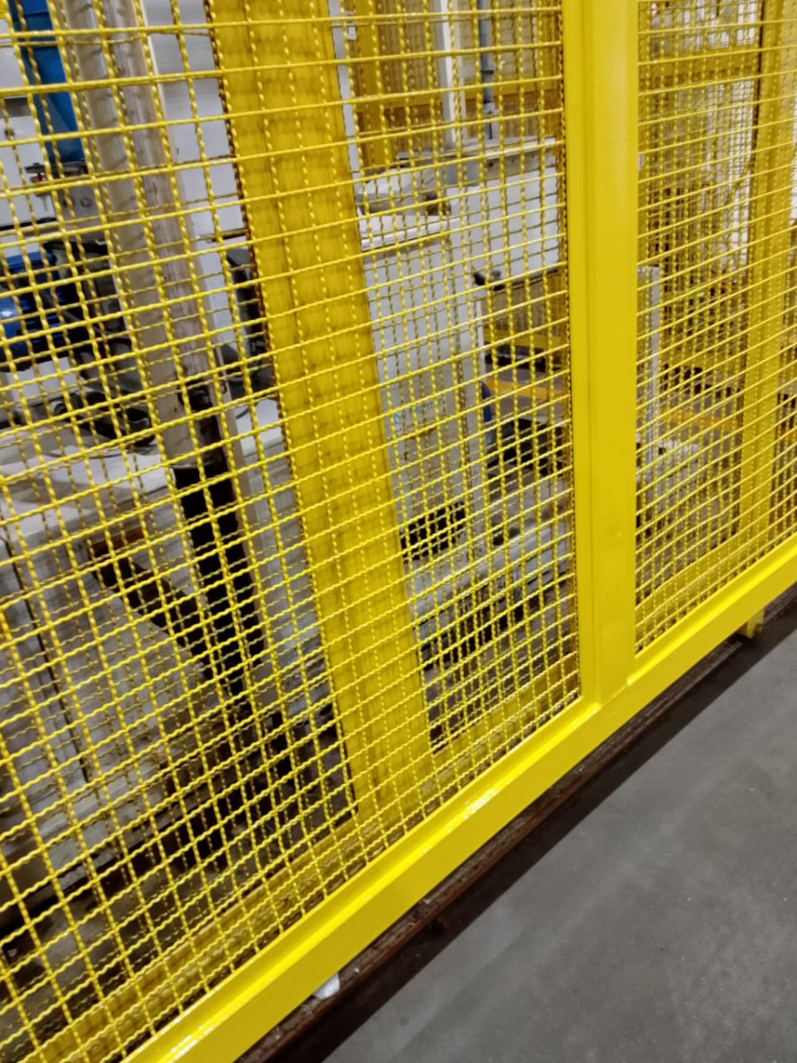 Barra de proteção amarela instalada junto a motor e bomba industrial, prevenção de acidente conforme NR-12